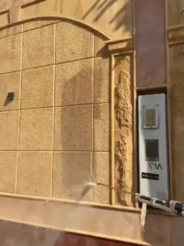 غسيل واجهة حجر بالمضخة عند مدخل بيت
