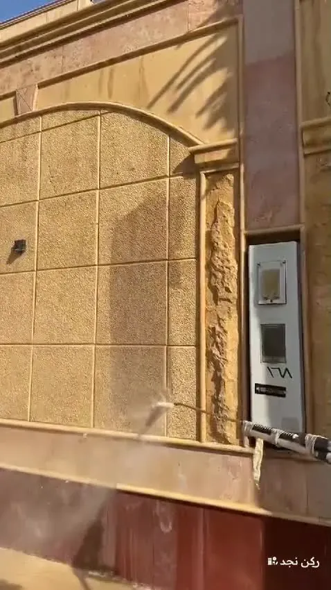غسيل واجهة حجر بالمضخة عند مدخل بيت